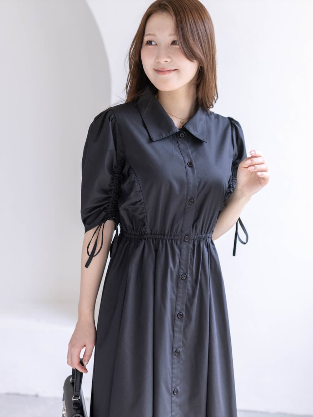 ブラック系のパンプス、ブラック系のハンドバッグ、ブラック系のワンピースを着用したレディースの春コーディネートの5枚目の写真