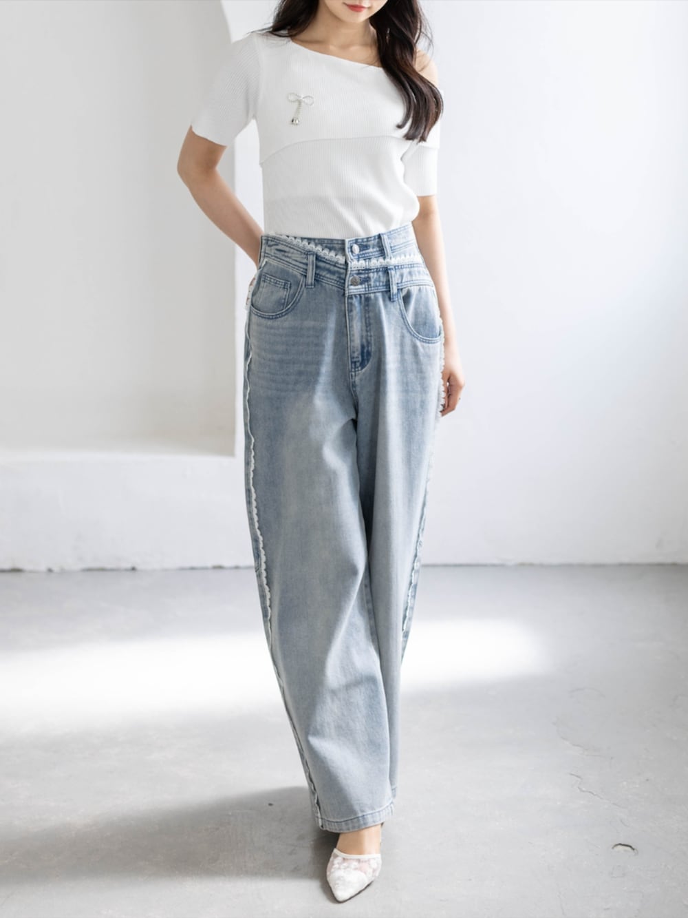 ブルー系のデニムパンツ、ホワイト系のパンプス、ホワイト系のニット/セーターを着用したレディースの春コーディネートの3枚目の写真