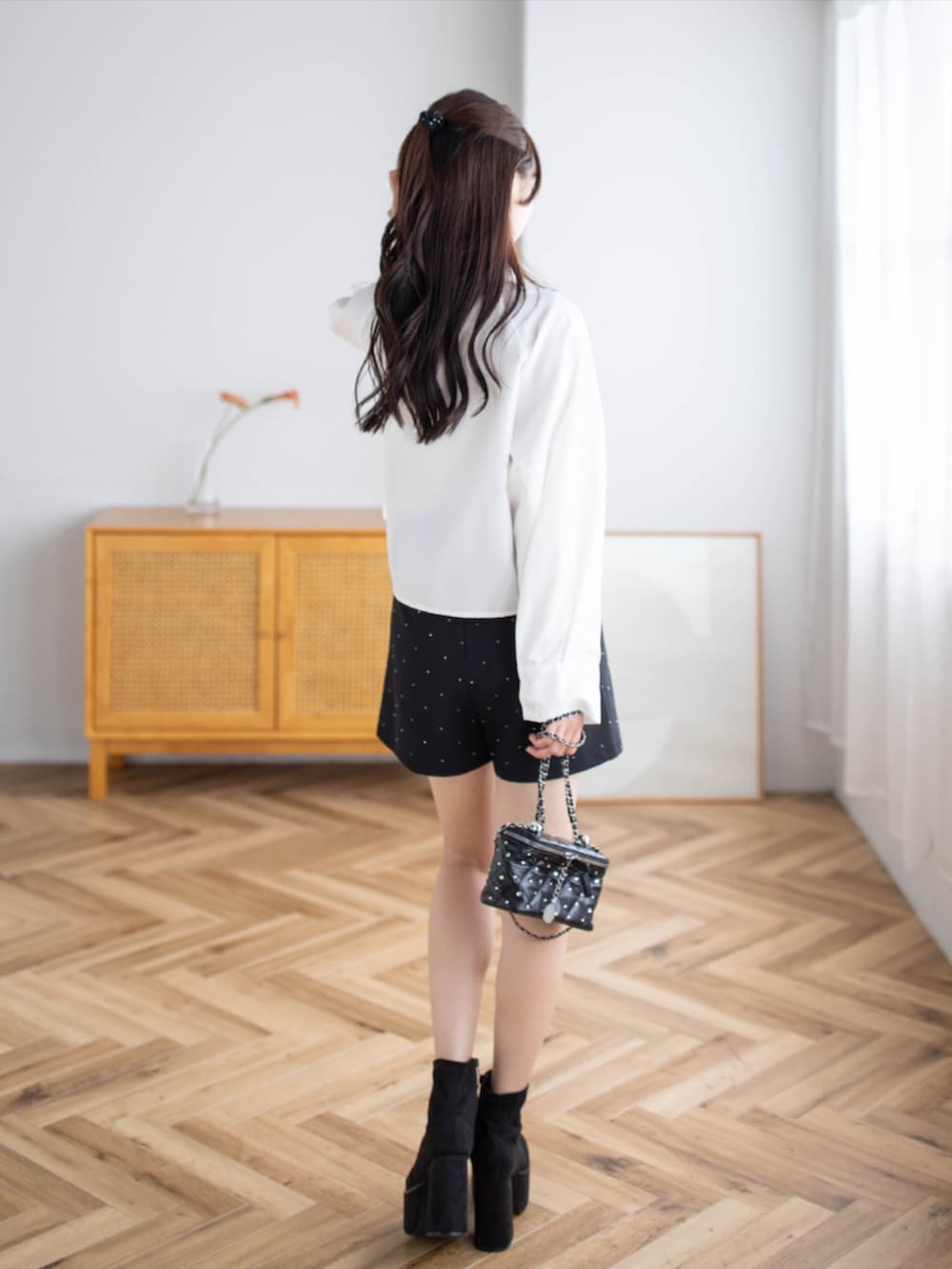 ブラック系のその他パンツ、ブラック系のブーツ、ホワイト系のシャツ/ブラウスを着用したレディースの秋コーディネートの2枚目の写真