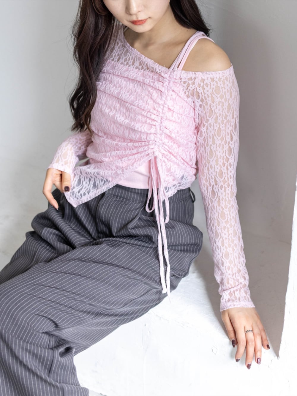 シルバー系のパンプス、グレー系のスラックス、ピンク系のアンサンブルを着用したレディースの春コーディネートの5枚目の写真