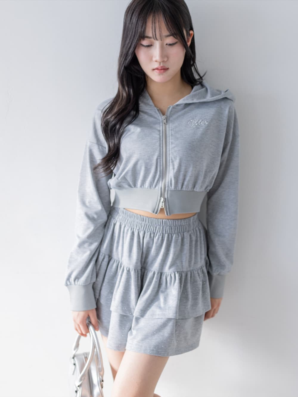 シルバー系のパンプス、グレー系のパーカー、グレー系のスカートを着用したレディースの春コーディネートの3枚目の写真
