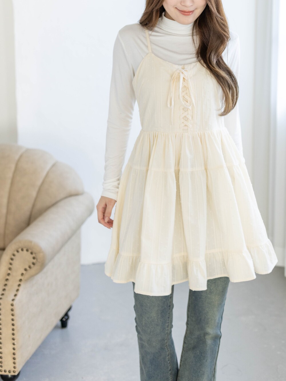 ブルー系のデニムパンツ、ホワイト系のTシャツ/カットソー、ベージュ系のワンピースを着用したレディースの春コーディネートの4枚目の写真