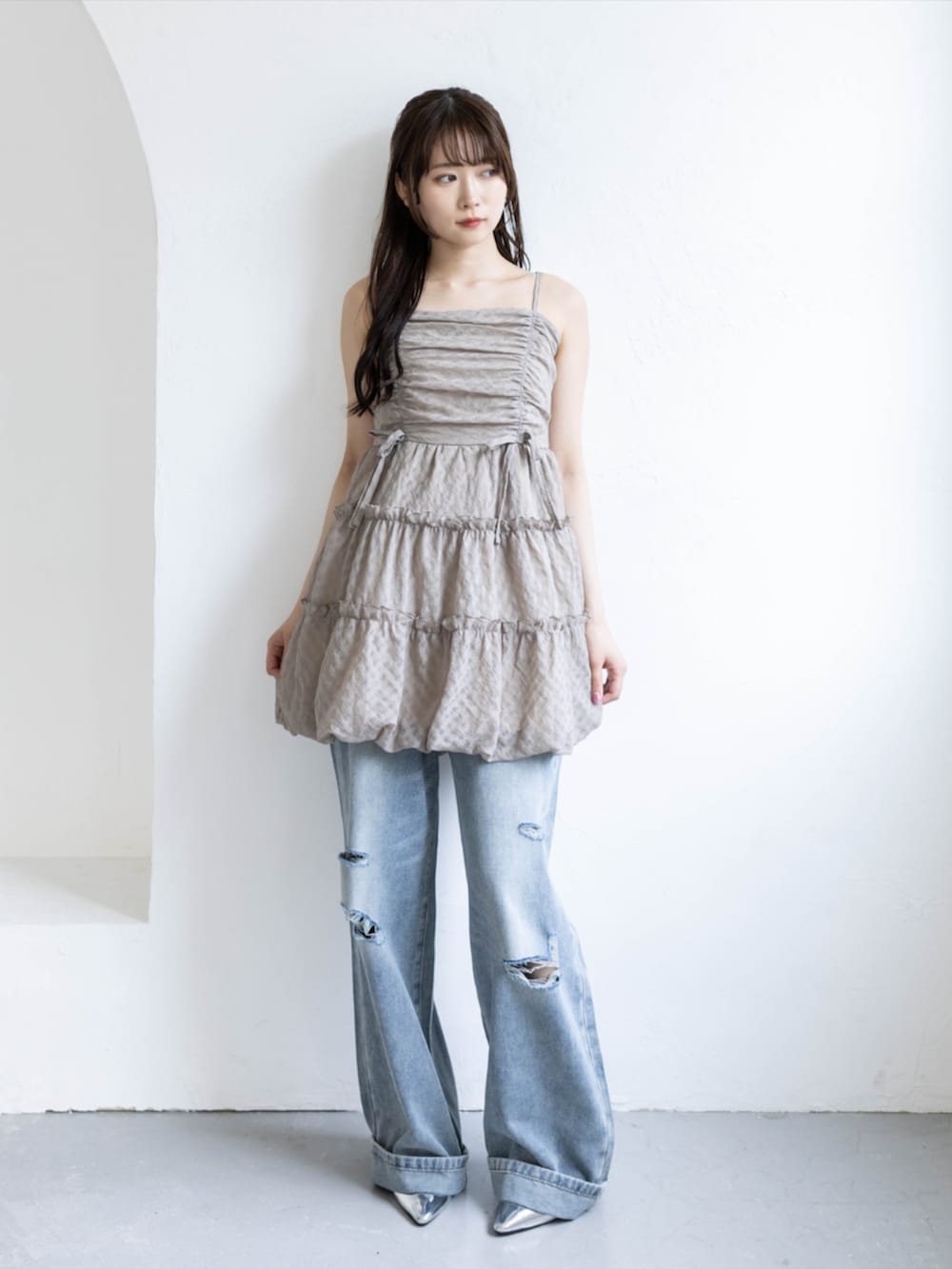 シルバー系のパンプス、ベージュ系のワンピース、ブルー系のデニムパンツを着用したレディースの夏コーディネートの3枚目の写真