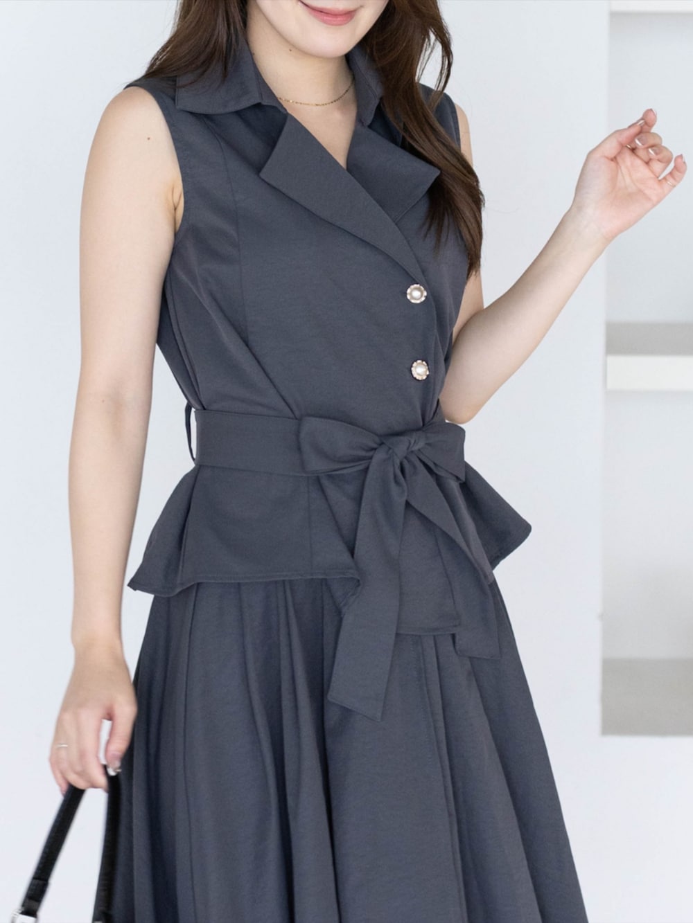 ブラック系のパンプス、グレー系のシャツ/ブラウス、グレー系のスカートを着用したレディースの夏コーディネートの10枚目の写真