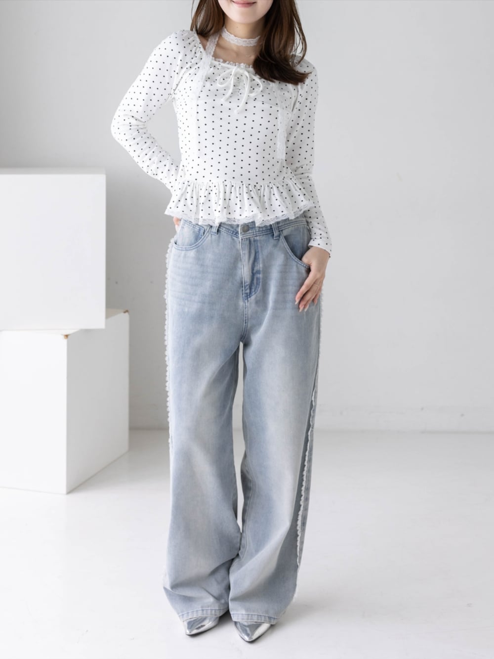 シルバー系のパンプス、ブルー系のデニムパンツ、ホワイト系のTシャツ/カットソーを着用したレディースの秋コーディネートの2枚目の写真