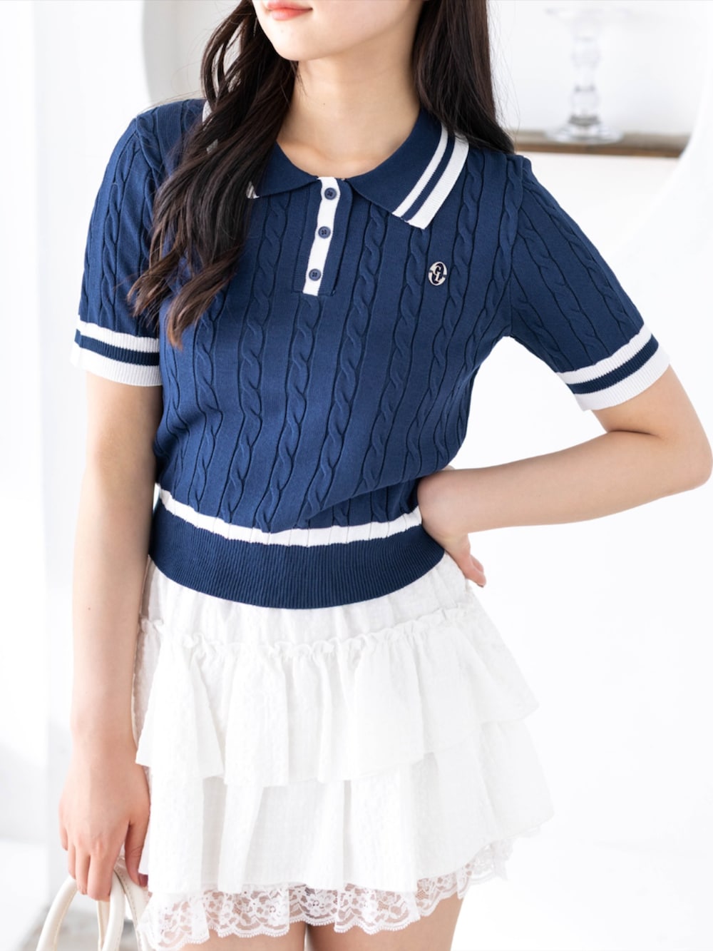 ホワイト系のハンドバッグ、ホワイト系のスカート、ブラック系のローファーを着用したレディースの春コーディネートの4枚目の写真