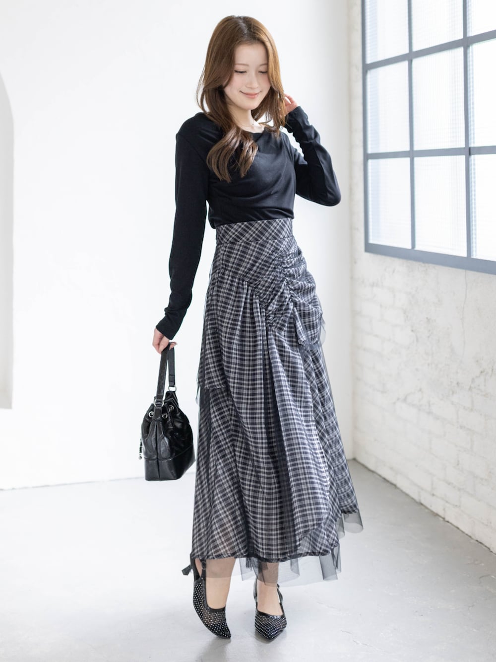 ブラック系のハンドバッグ、ブラック系のTシャツ/カットソー、ブラック系のスカートを着用したレディースの春コーディネートの3枚目の写真