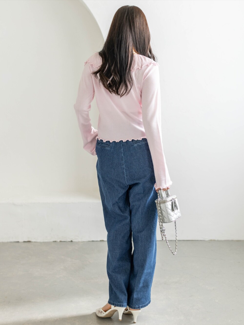 ホワイト系のパンプス、ブルー系のデニムパンツ、ピンク系のカーディガン/ボレロを着用したレディースの春コーディネートの3枚目の写真