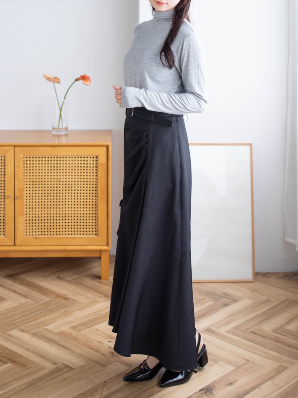ブラック系のパンプス、ブラック系のハンドバッグ、グレー系のTシャツ/カットソーを着用したレディースの夏コーディネートの2枚目の写真