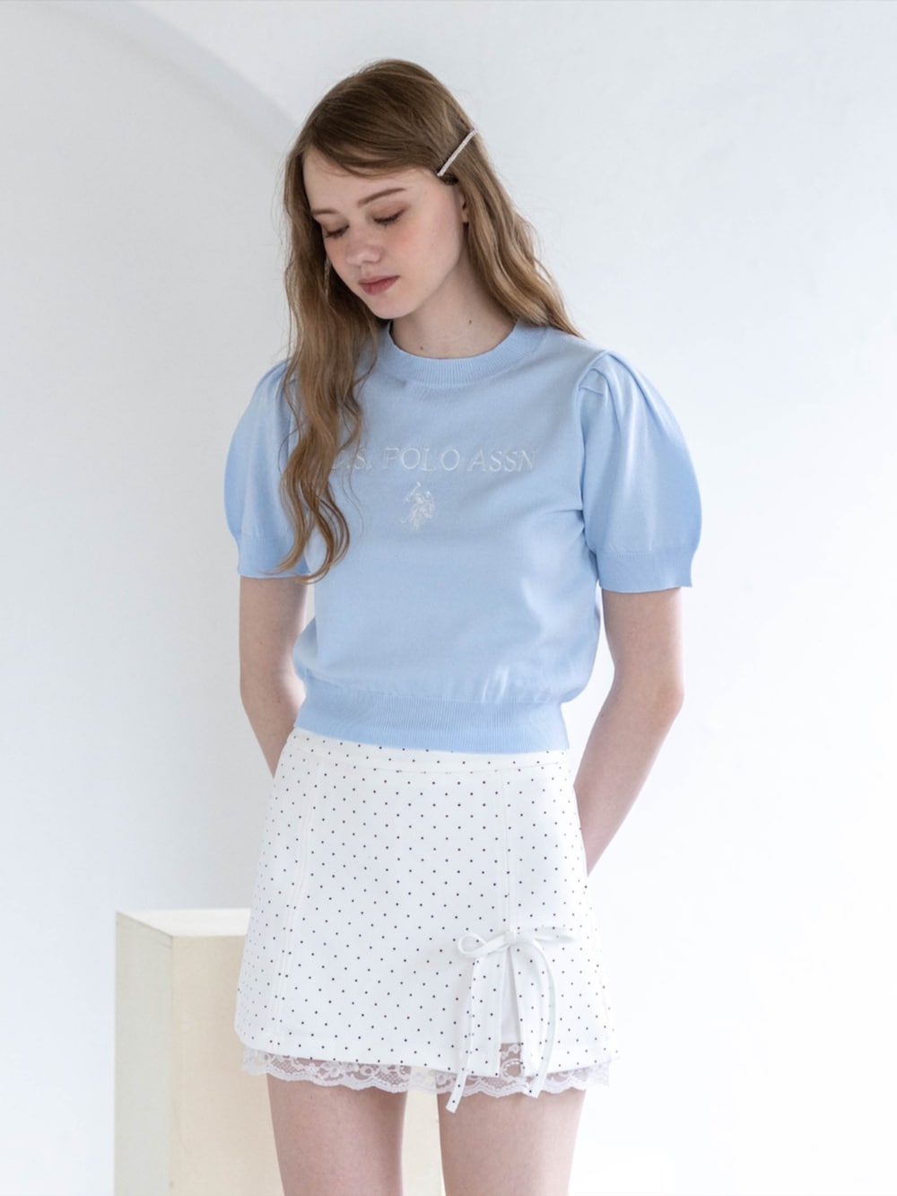 シルバー系のパンプス、ホワイト系のスカート、ブルー系のニット/セーターを着用したレディースの夏コーディネートの7枚目の写真