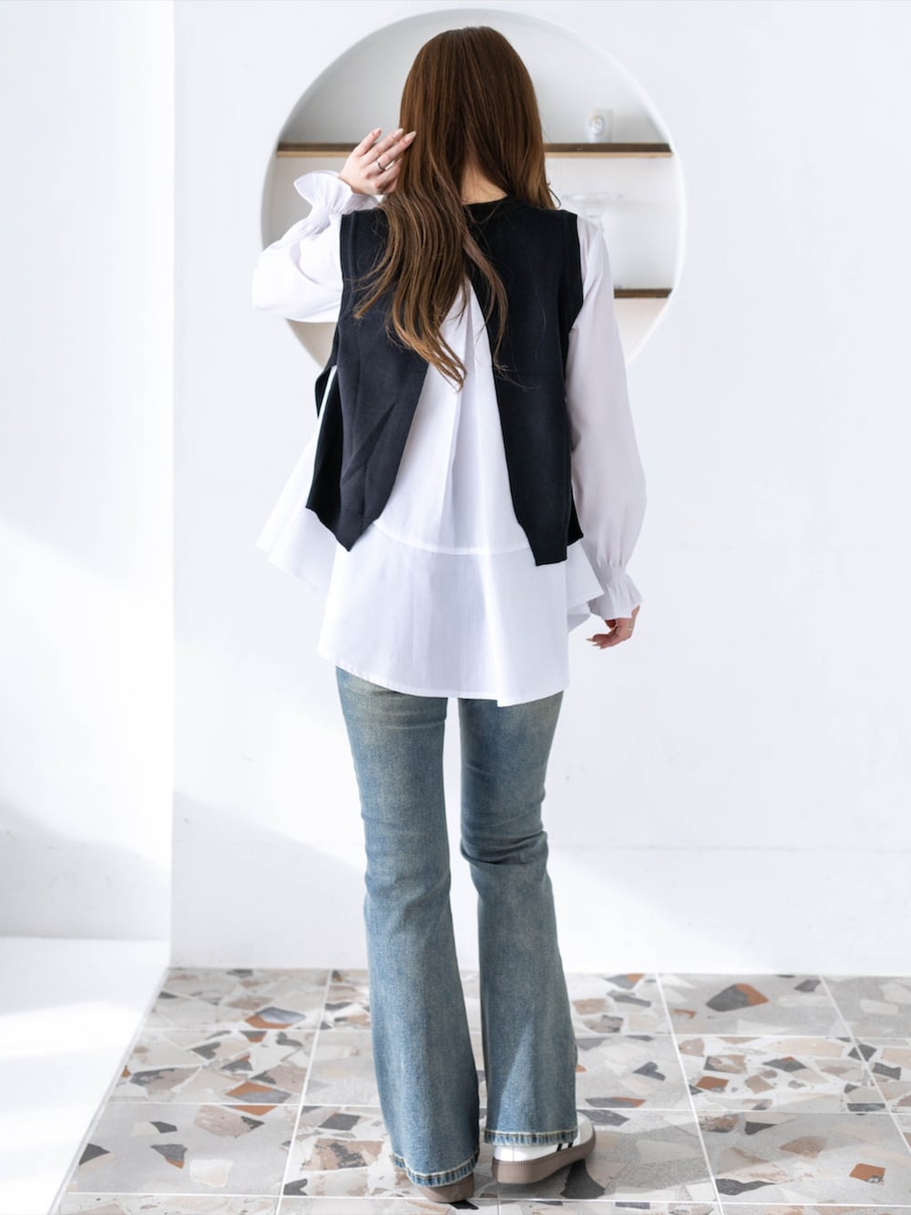 ブルー系のデニムパンツ、ホワイト系のスニーカー、ブラック系のシャツ/ブラウスを着用したレディースの冬コーディネートの2枚目の写真