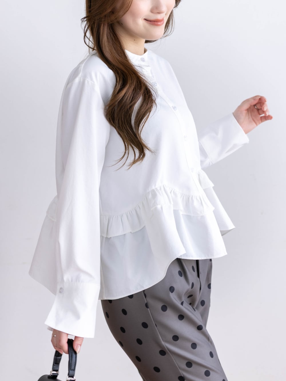 ブラック系のパンプス、ホワイト系のシャツ/ブラウス、グレー系のスラックスを着用したレディースの冬コーディネートの5枚目の写真