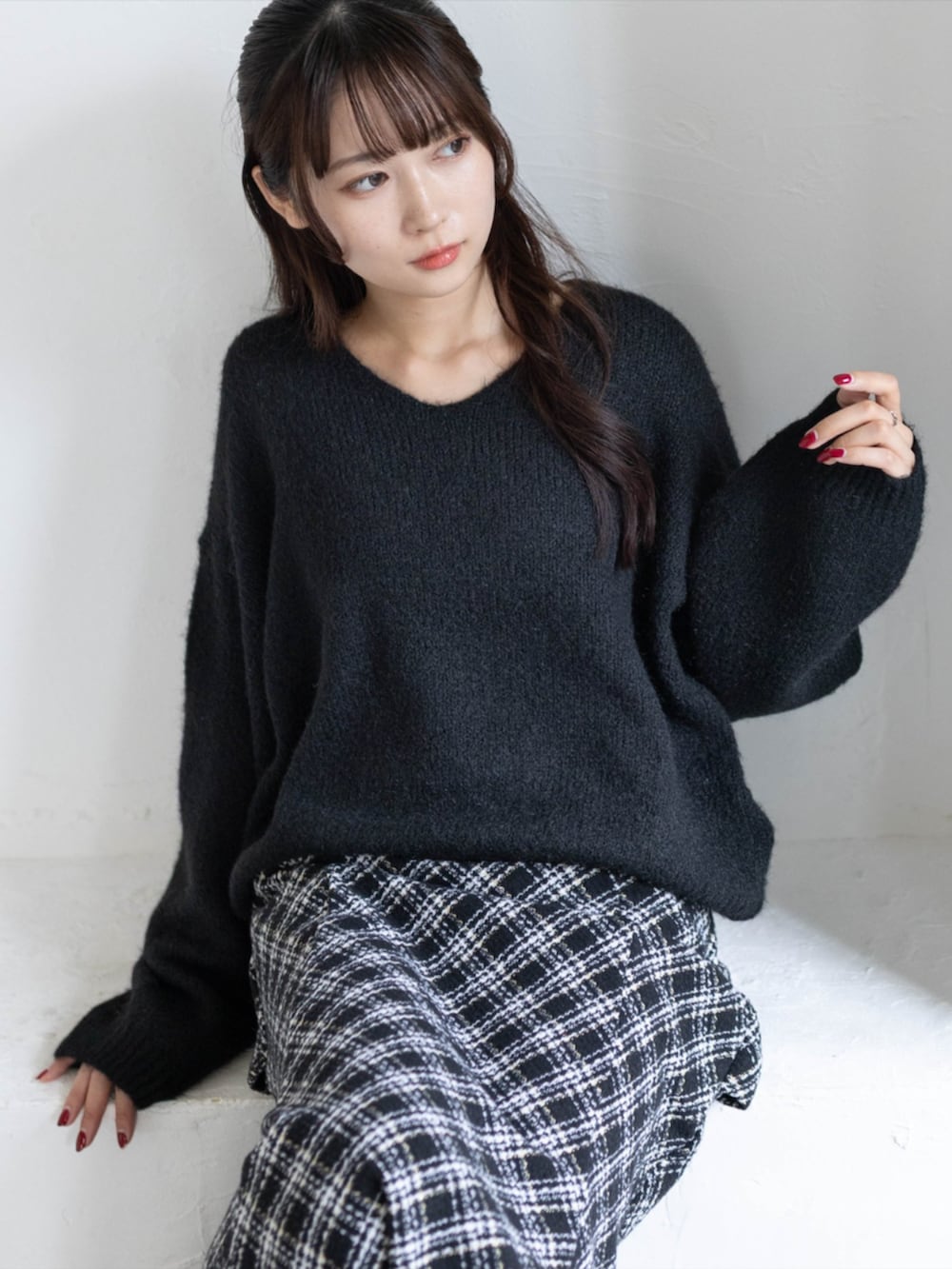 ブラック系のスカート、ブラック系のパンプス、ブラック系のニット/セーターを着用したレディースの秋コーディネートの5枚目の写真