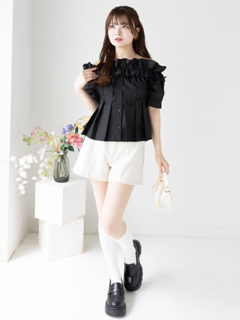 ホワイト系のその他パンツ、ホワイト系のショルダーバッグ、ブラック系のシャツ/ブラウスを着用したレディースの春コーディネートの2枚目の写真