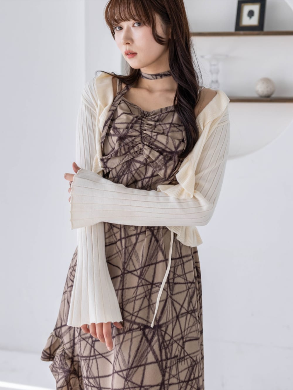 ブラック系のブーツ、ホワイト系のカーディガン/ボレロ、ベージュ系のワンピースを着用したレディースの春コーディネートの5枚目の写真