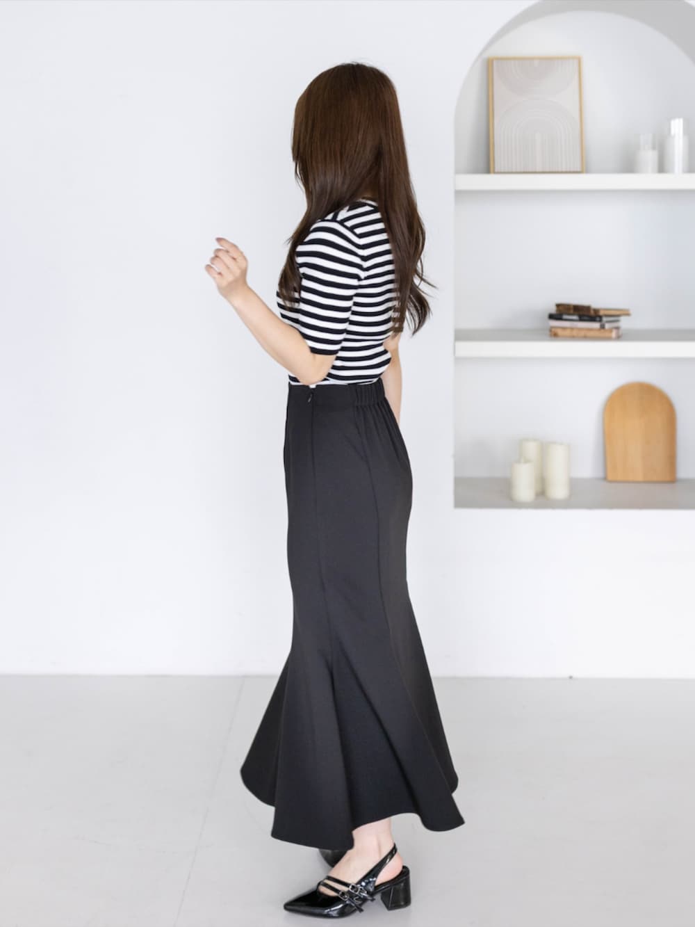 ブラック系のニット/セーター、ブラック系のパンプス、ブラック系のスカートを着用したレディースの夏コーディネートの2枚目の写真