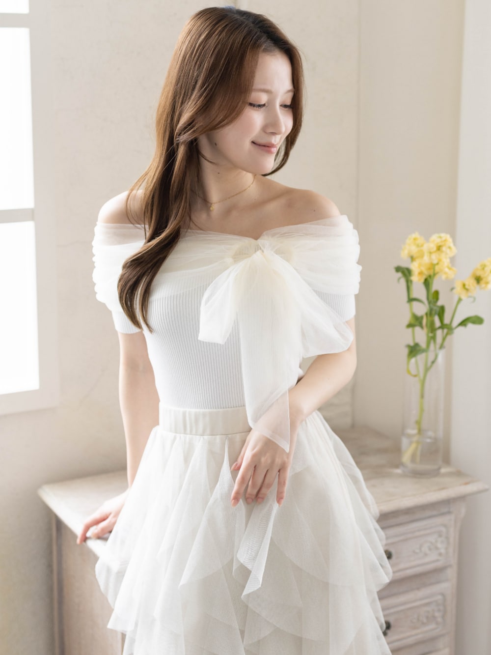 ホワイト系のニット/セーター、ホワイト系のパンプス、ホワイト系のスカートを着用したレディースの春コーディネートの7枚目の写真