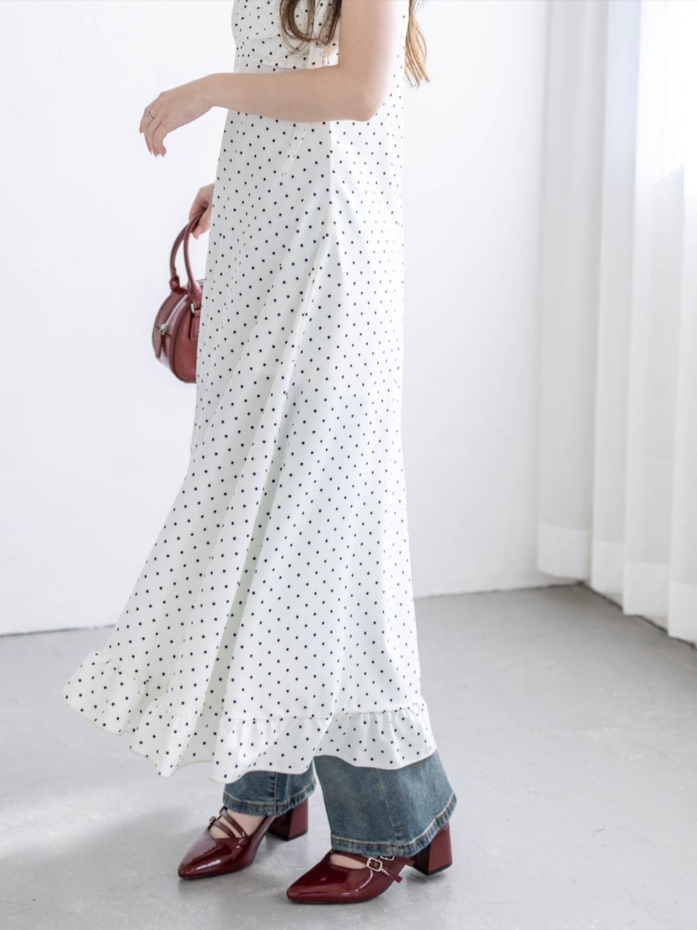 レッド系のパンプス、ブルー系のデニムパンツ、ホワイト系のワンピースを着用したレディースの夏コーディネートの8枚目の写真