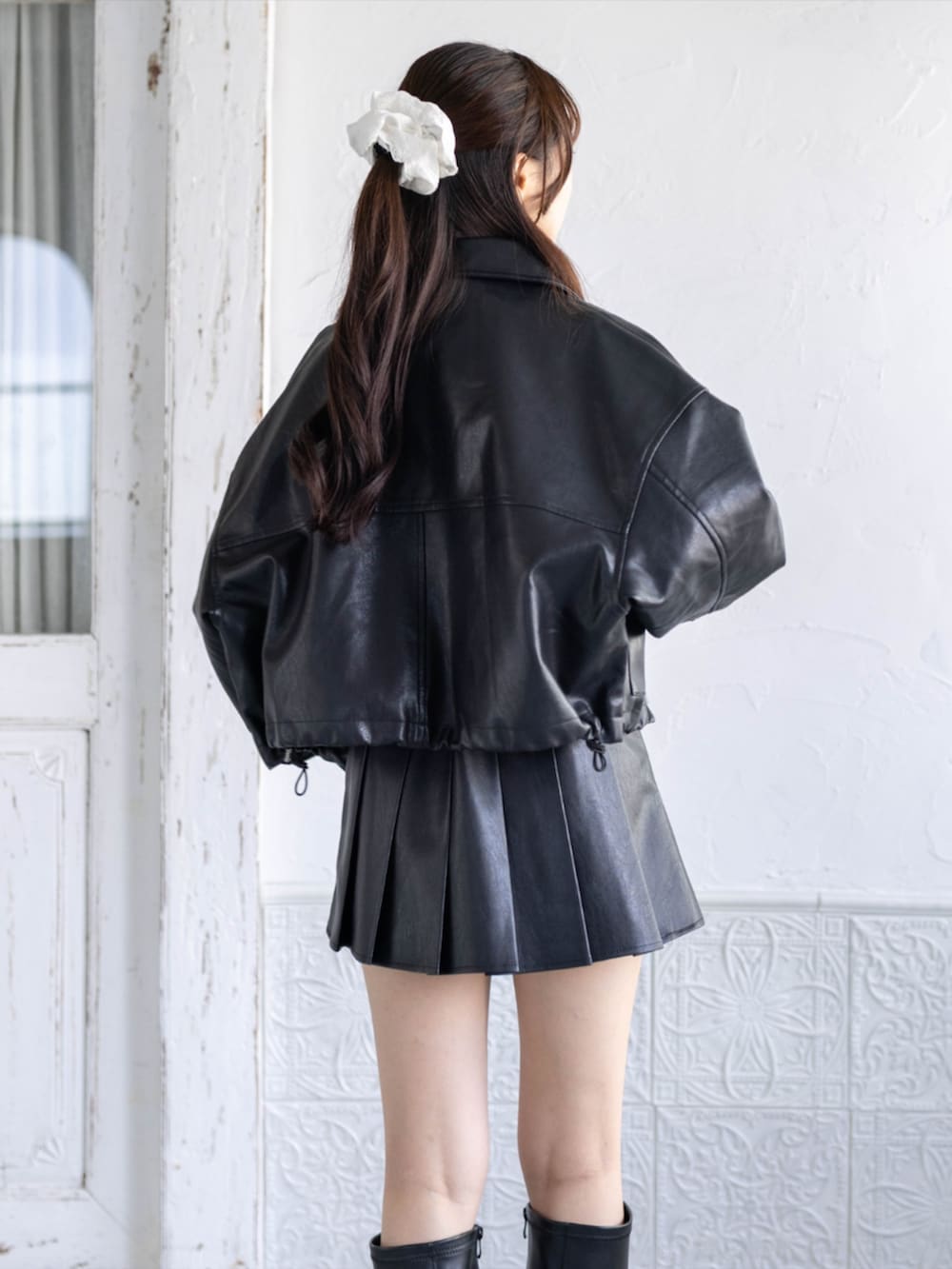 ブラック系のスカート、ブラック系のブーツ、グレー系のTシャツ/カットソーを着用したレディースの秋コーディネートの3枚目の写真