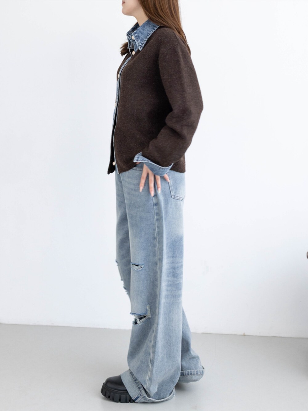 ブルー系のデニムパンツ、ブラック系のブーツ、ブラウン系のニット/セーターを着用したレディースの秋コーディネートの4枚目の写真