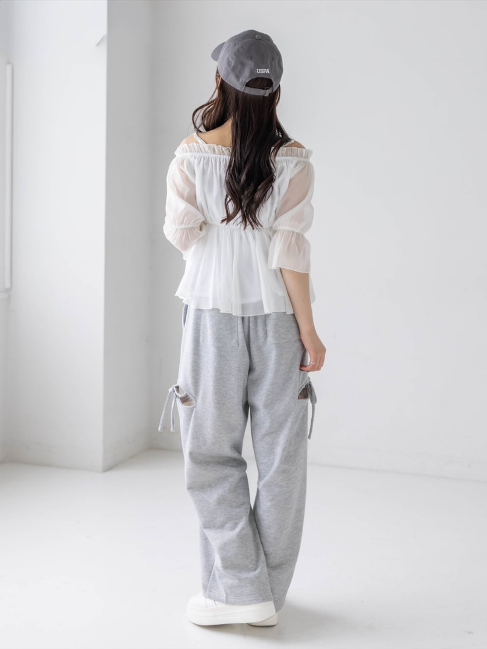 グレー系のスウェットパンツ、ホワイト系のシャツ/ブラウス、グレー系のキャップを着用したレディースの春コーディネートの4枚目の写真
