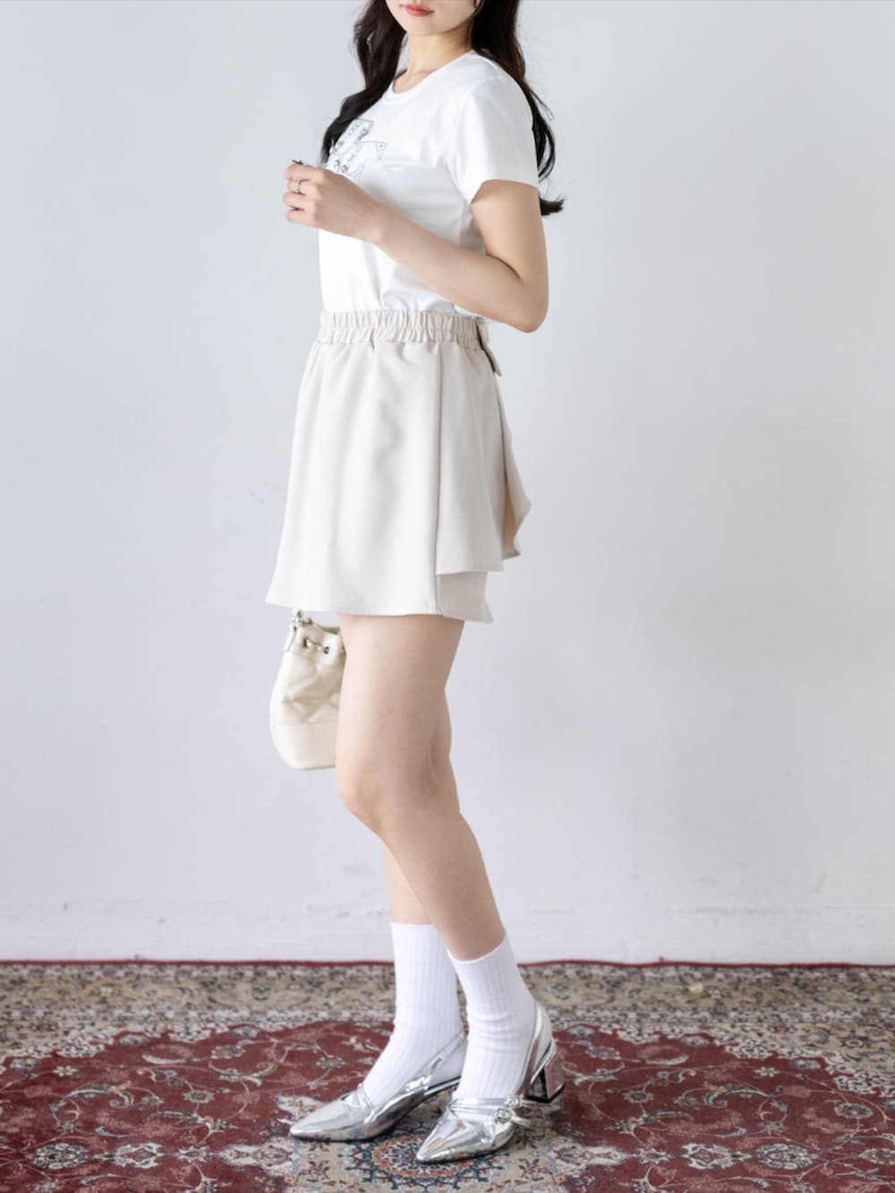 シルバー系のパンプス、ホワイト系のTシャツ/カットソー、ホワイト系のスカートを着用したレディースの夏コーディネートの3枚目の写真