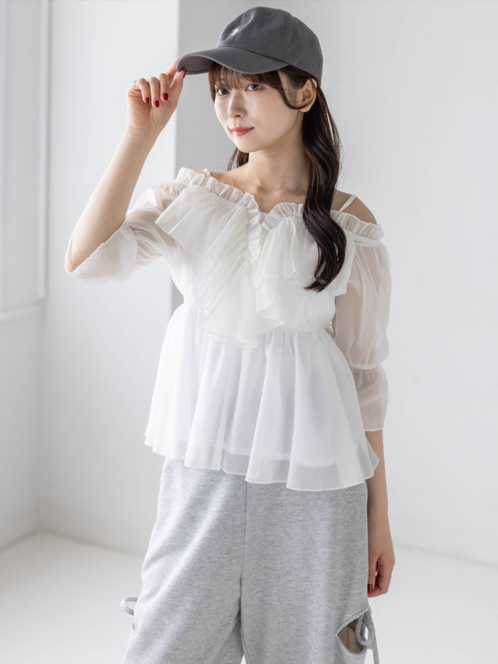 グレー系のスウェットパンツ、ホワイト系のシャツ/ブラウス、グレー系のキャップを着用したレディースの春コーディネートの7枚目の写真