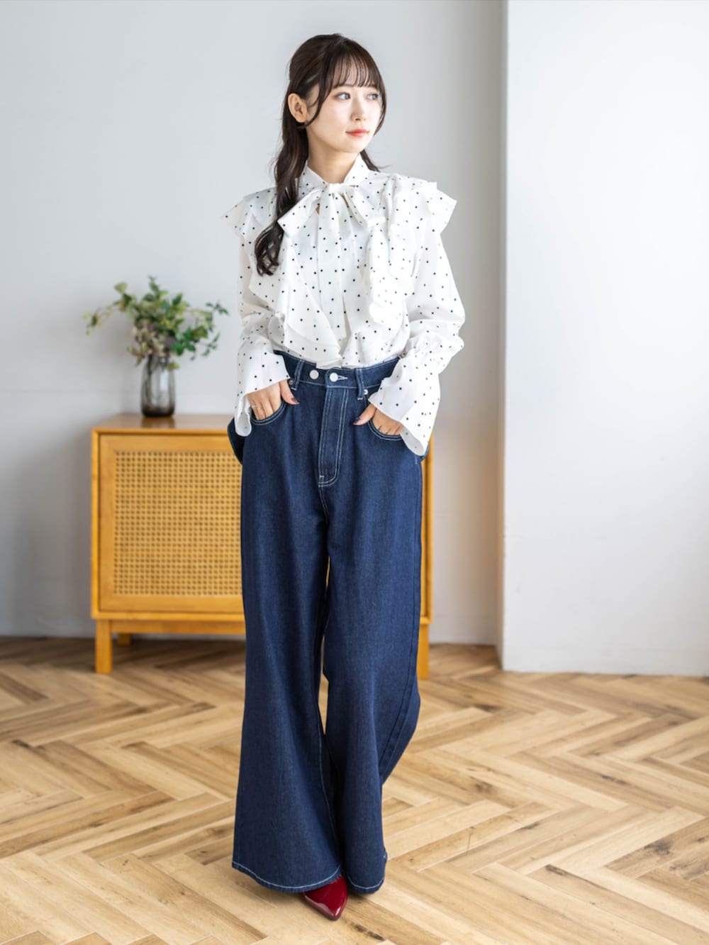 レッド系のパンプス、ホワイト系のシャツ/ブラウス、ブルー系のデニムパンツを着用したレディースの夏コーディネートの4枚目の写真