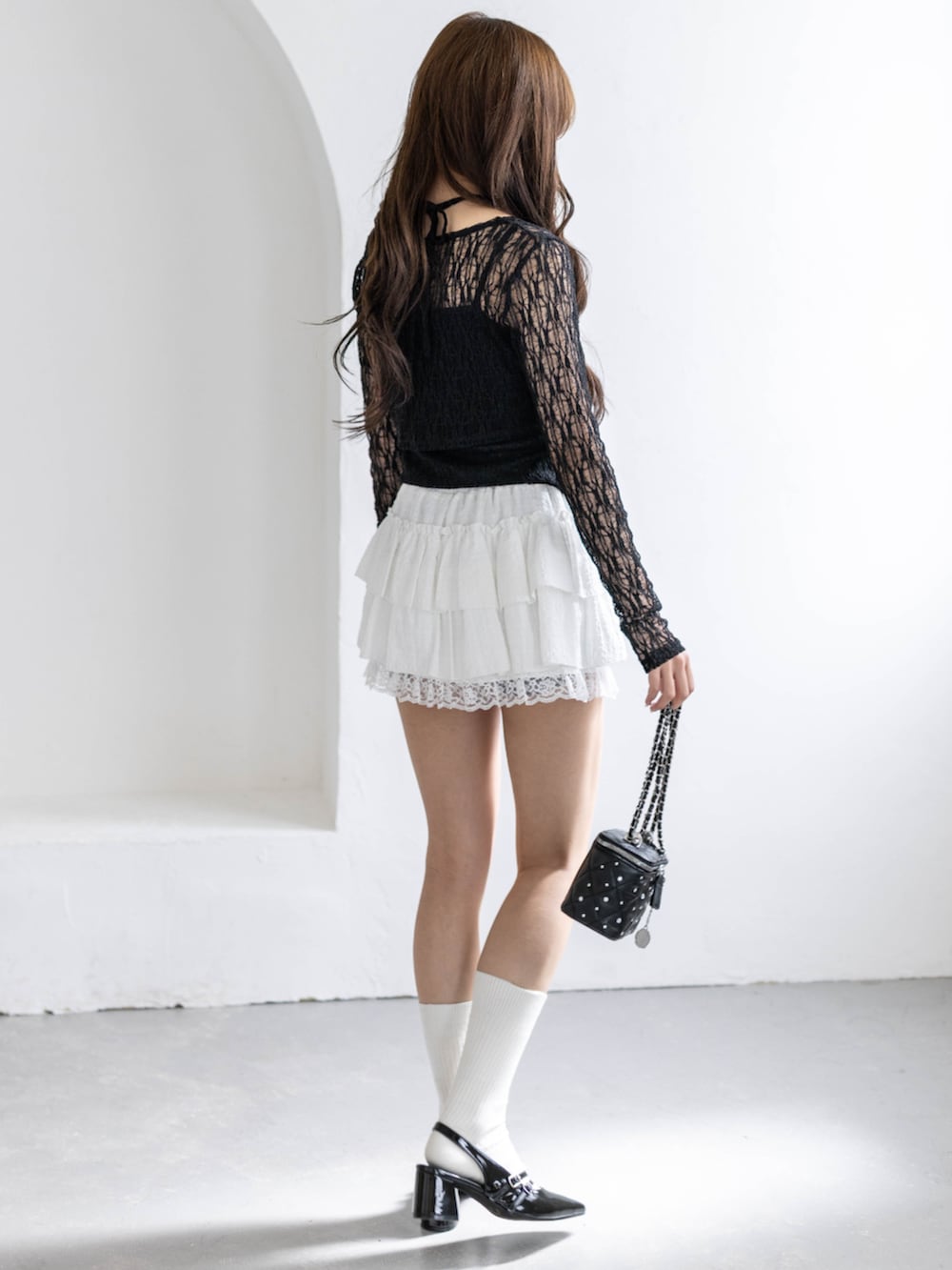 ブラック系のパンプス、ブラック系のショルダーバッグ、ブラック系のカーディガン/ボレロを着用したレディースの春コーディネートの4枚目の写真