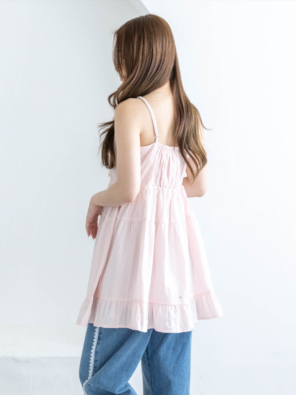 シルバー系のパンプス、ブルー系のデニムパンツ、ピンク系のワンピースを着用したレディースの夏コーディネートの3枚目の写真