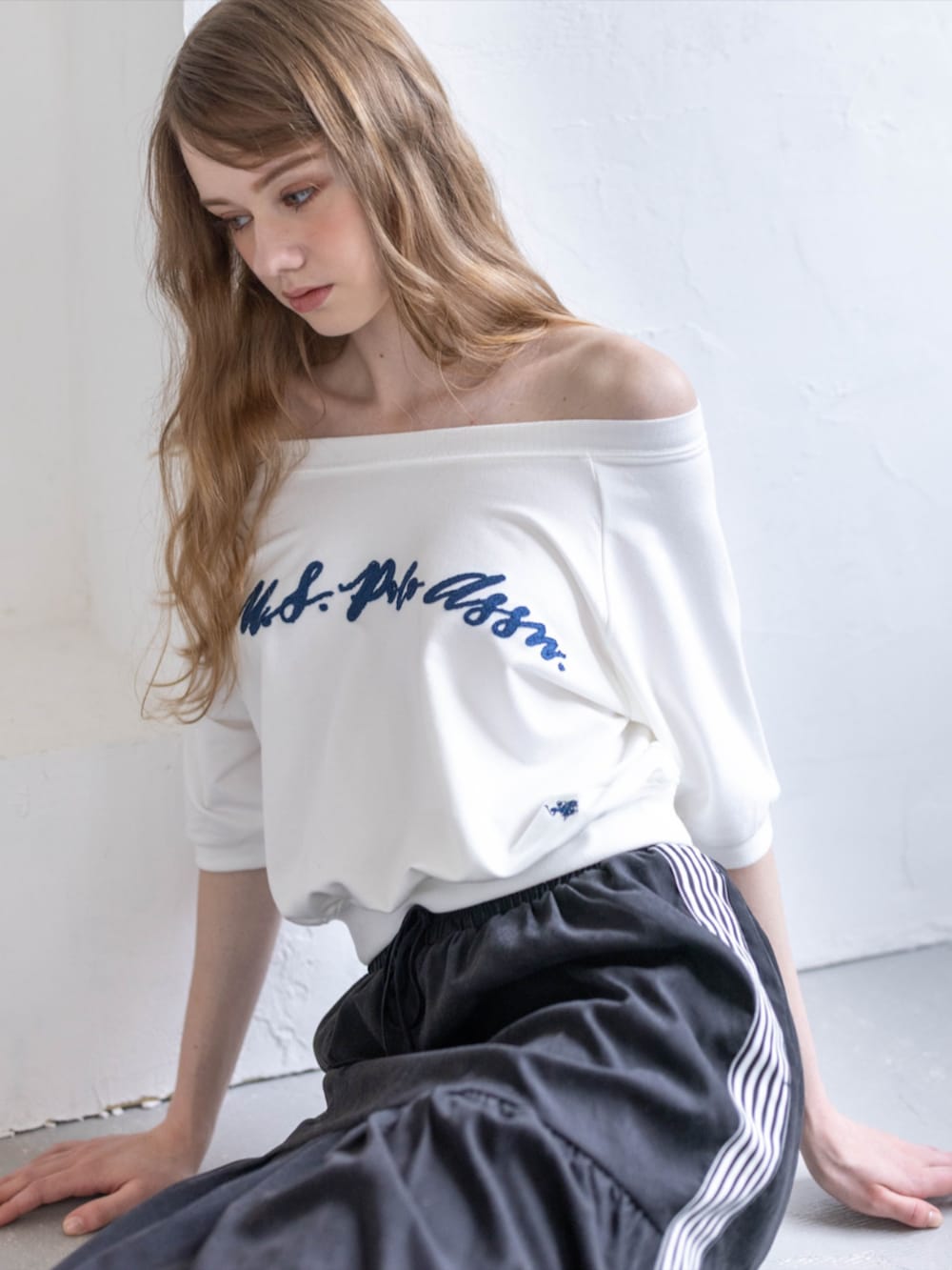 ブラック系のスニーカー、ブラック系のスカート、ホワイト系のTシャツ/カットソーを着用したレディースの夏コーディネートの7枚目の写真