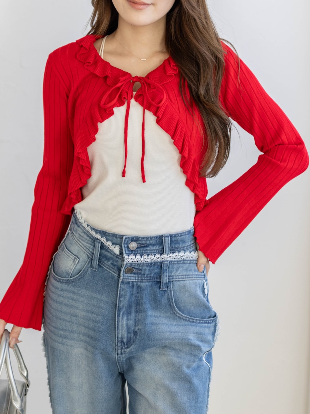 ブルー系のデニムパンツ、レッド系のカーディガン/ボレロを着用したレディースの冬コーディネートの5枚目の写真