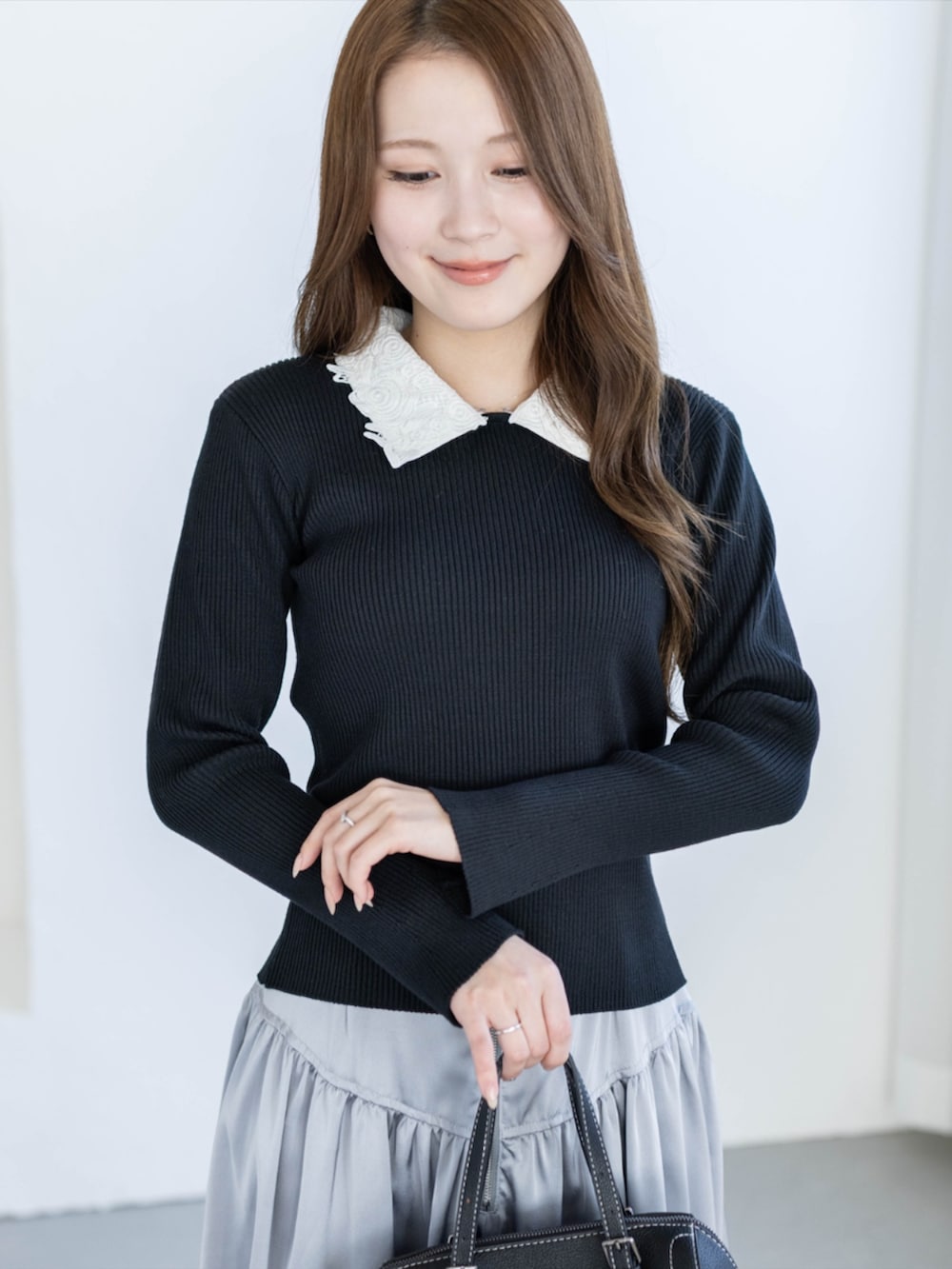 ブラック系のパンプス、グレー系のスカート、ブラック系のニット/セーターを着用したレディースの夏コーディネートの9枚目の写真