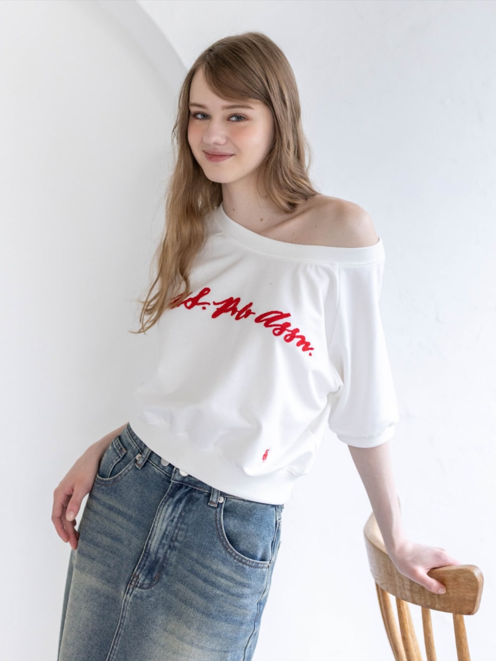 ブラック系のブーツ、ホワイト系のTシャツ/カットソー、ブルー系のデニムスカートを着用したレディースの夏コーディネートの7枚目の写真