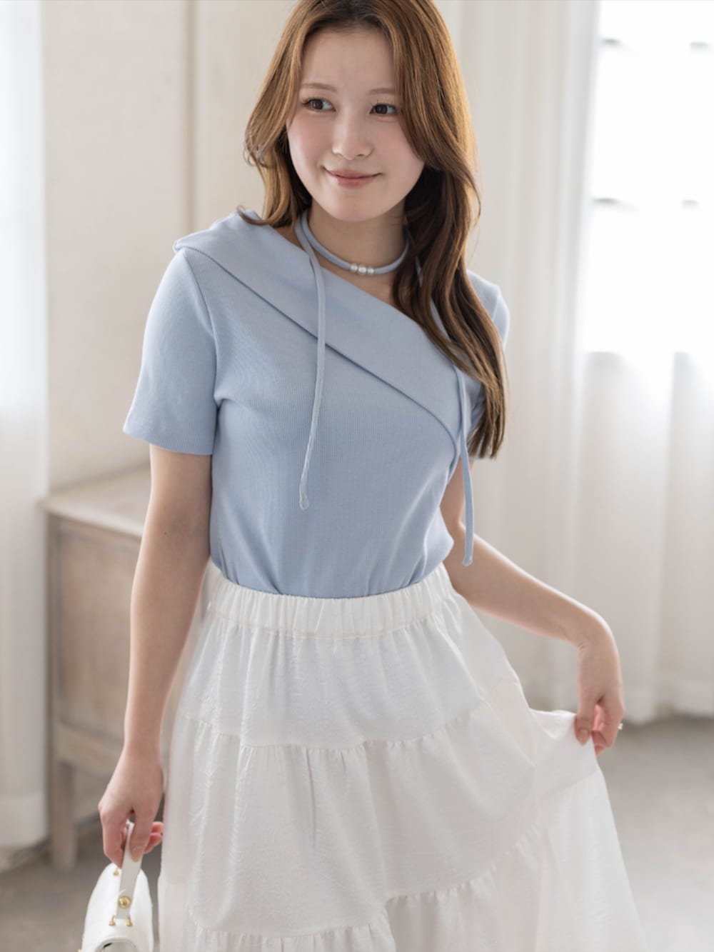ホワイト系のスカート、ホワイト系のパンプス、ブルー系のTシャツ/カットソーを着用したレディースの春コーディネートの4枚目の写真