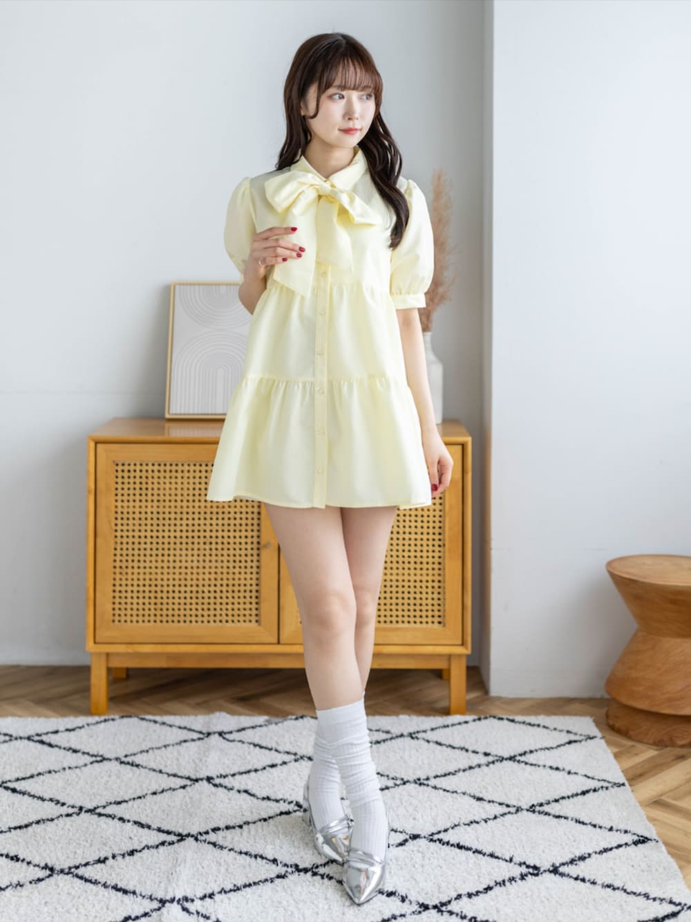 シルバー系のパンプス、イエロー系のワンピースを着用したレディースの春コーディネートの2枚目の写真