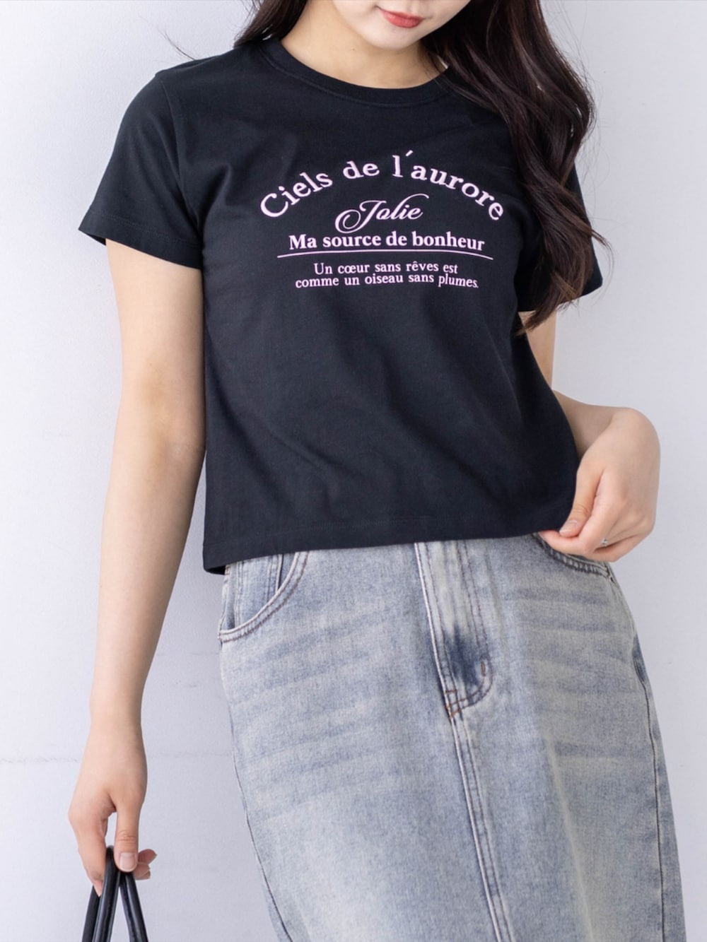 ホワイト系のスニーカー、ブルー系のスカート、ブラック系のTシャツ/カットソーを着用したレディースの春コーディネートの4枚目の写真