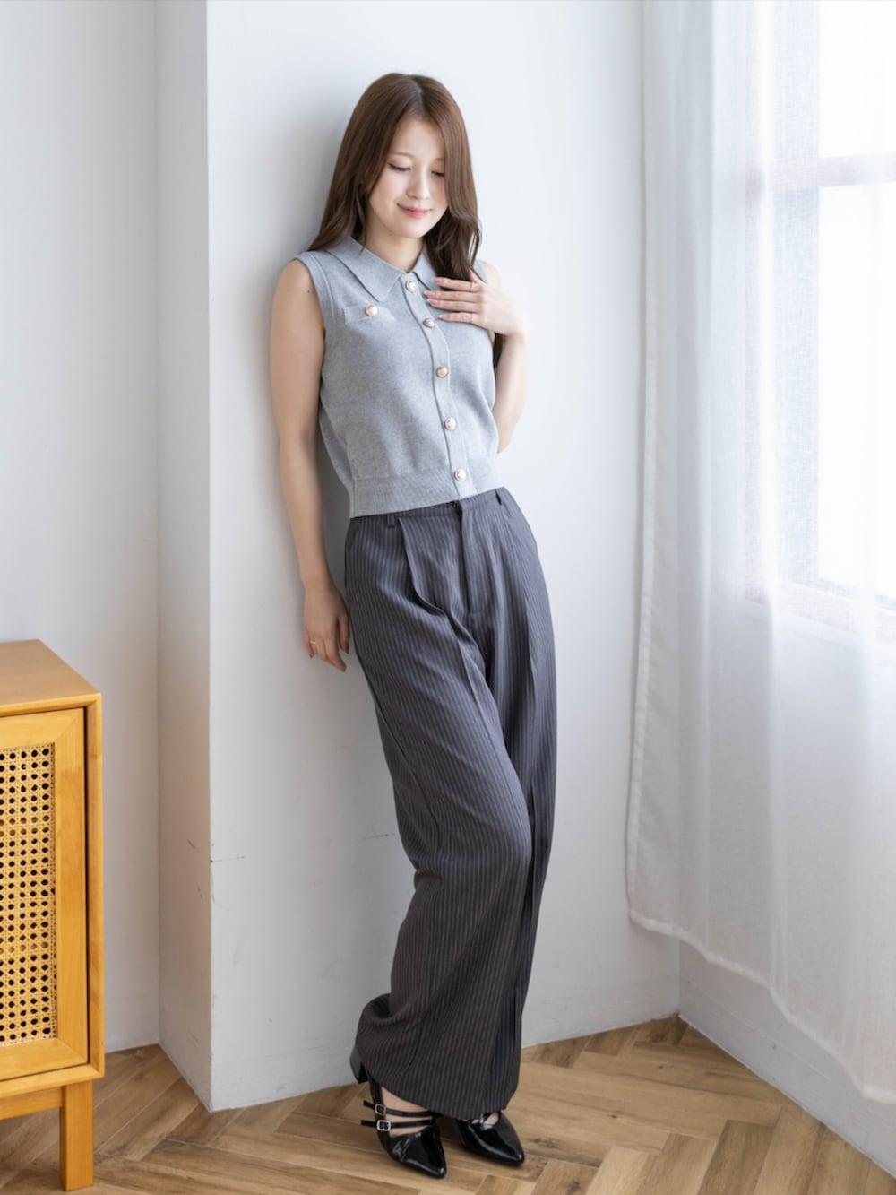 ブラック系のパンプス、グレー系のスラックス、グレー系のニット/セーターを着用したレディースの夏コーディネートの2枚目の写真