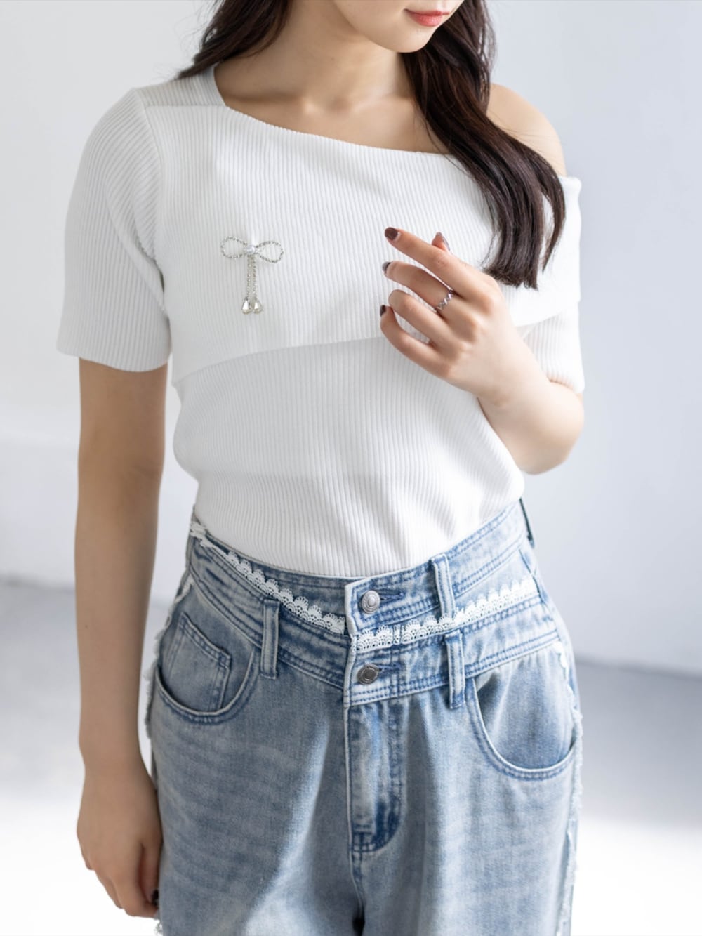 ブルー系のデニムパンツ、ホワイト系のパンプス、ホワイト系のニット/セーターを着用したレディースの春コーディネートの4枚目の写真