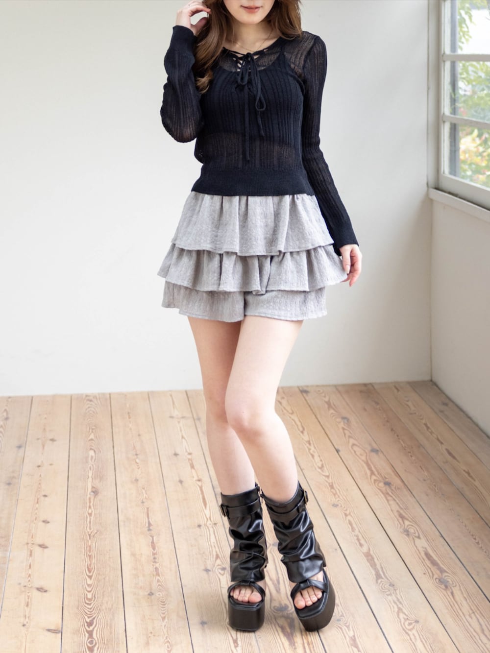 ブラック系のニット/セーター、グレー系のその他パンツ、ブラック系のサンダルを着用したレディースの春コーディネートの2枚目の写真