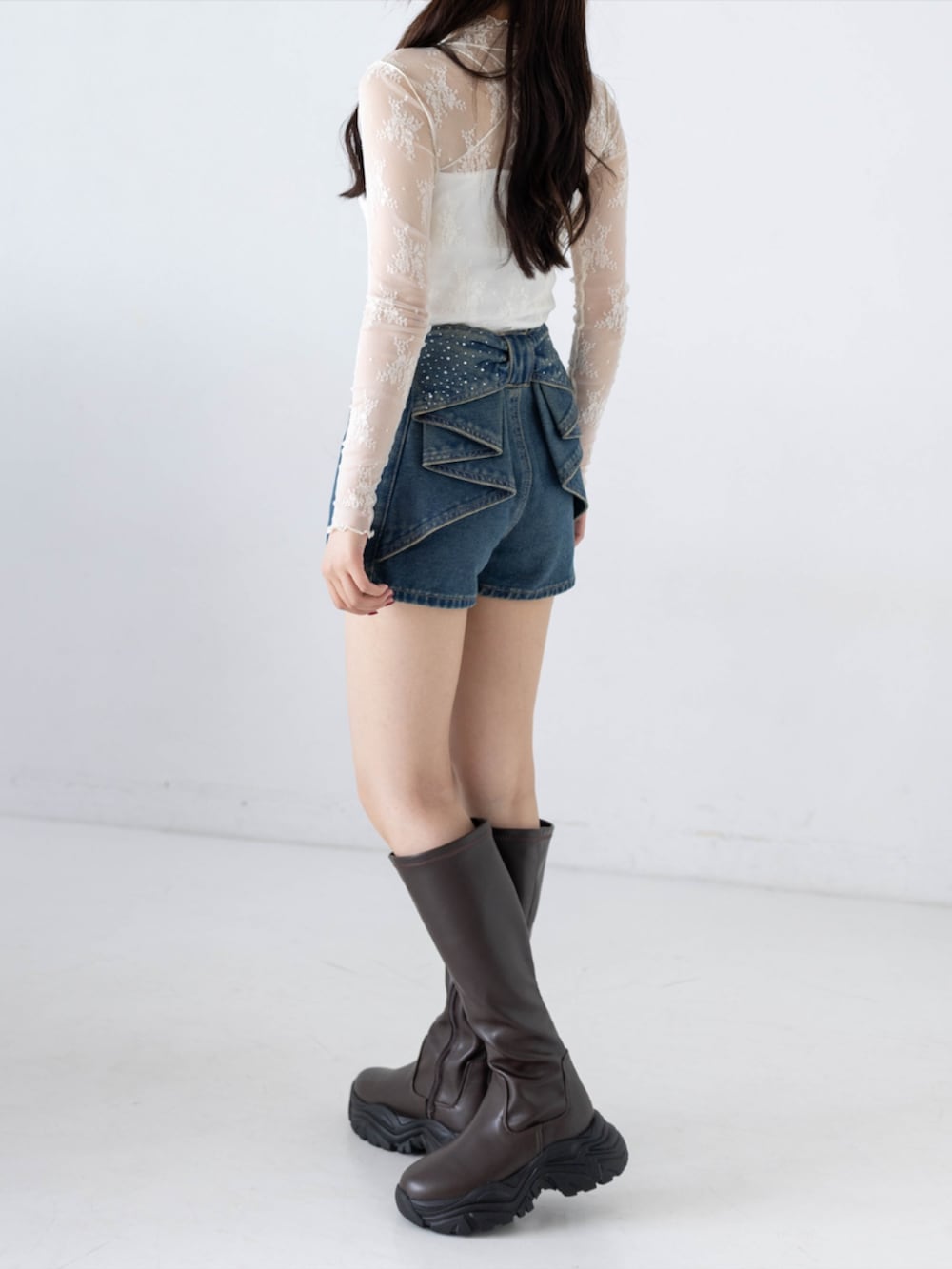 ブルー系のデニムパンツ、ホワイト系のTシャツ/カットソー、ブラウン系のブーツを着用したレディースの秋コーディネートの4枚目の写真