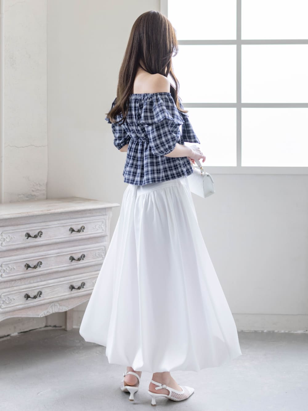 ホワイト系のスカート、ホワイト系のパンプス、ブルー系のシャツ/ブラウスを着用したレディースの春コーディネートの3枚目の写真