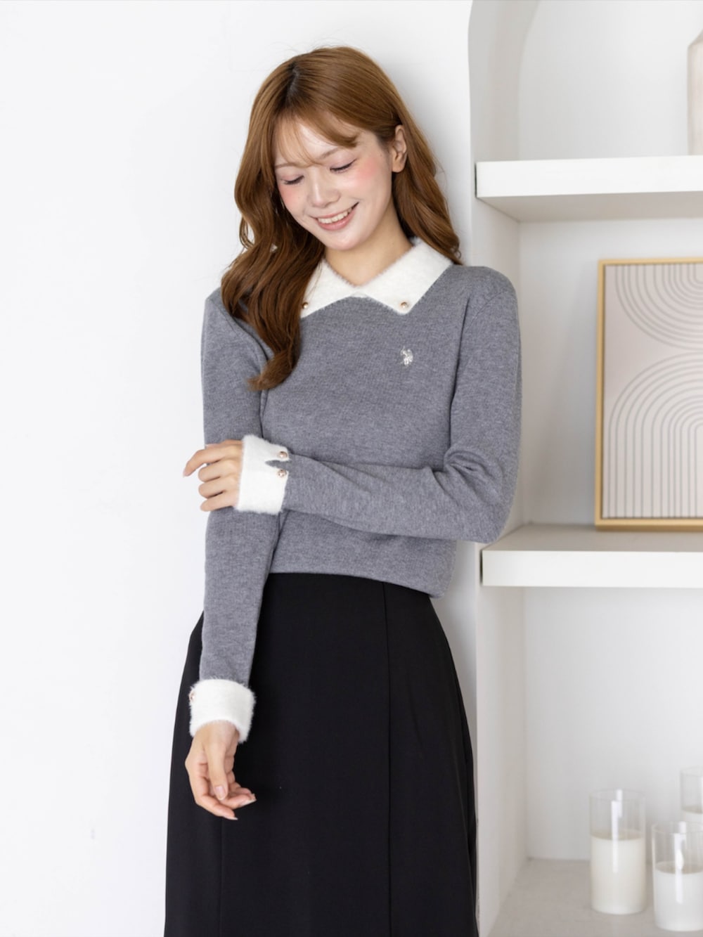 ブラック系のスカート、ブラック系のパンプス、グレー系のニット/セーターを着用したレディースの秋コーディネートの4枚目の写真