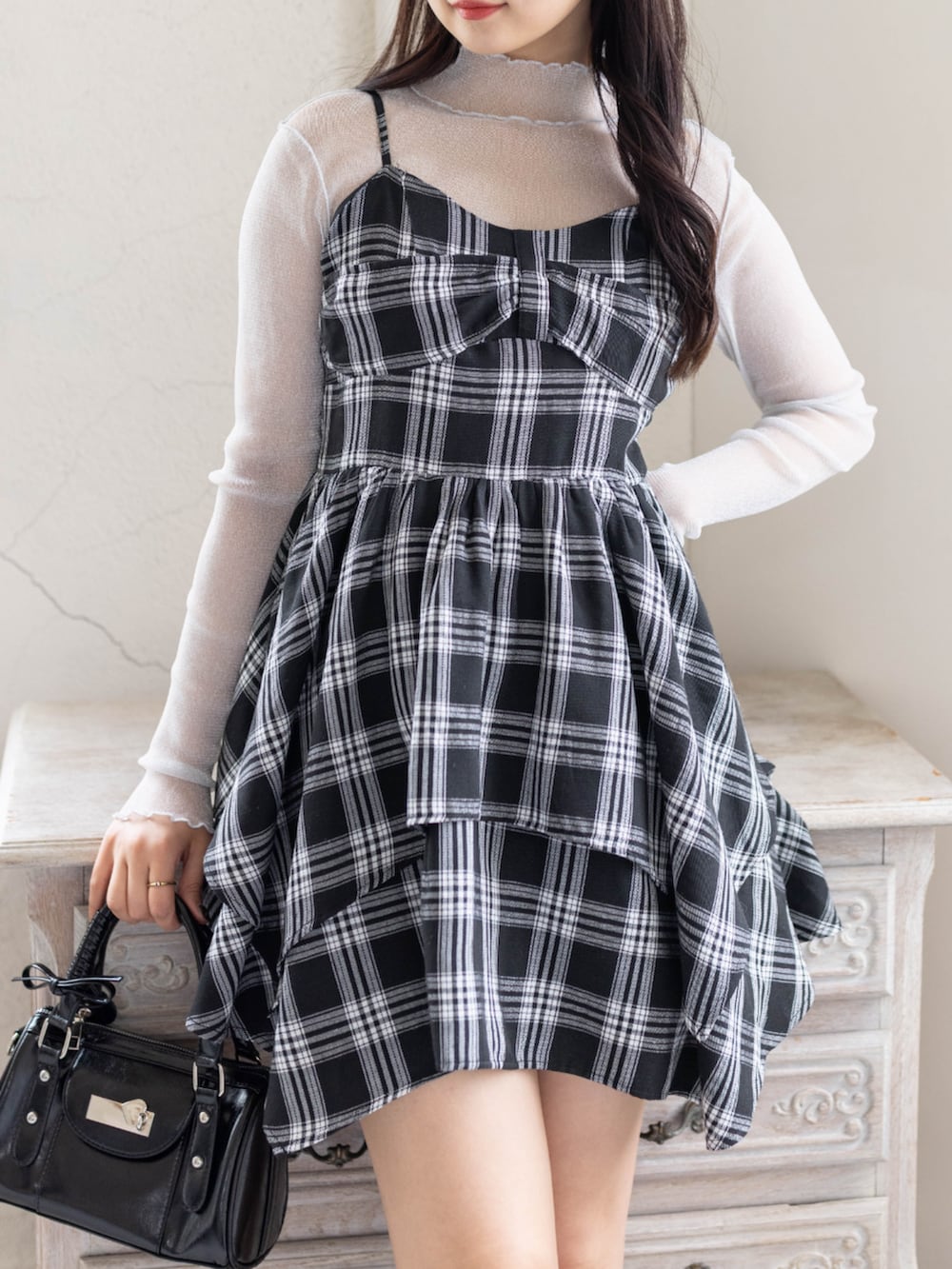 グレー系のTシャツ/カットソー、ブラック系のワンピース、ブラック系のブーツを着用したレディースの春コーディネートの4枚目の写真