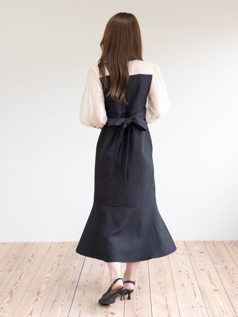 ブラック系のハンドバッグ、ブラック系のパンプス、ブラック系のワンピースを着用したレディースの春コーディネートの4枚目の写真