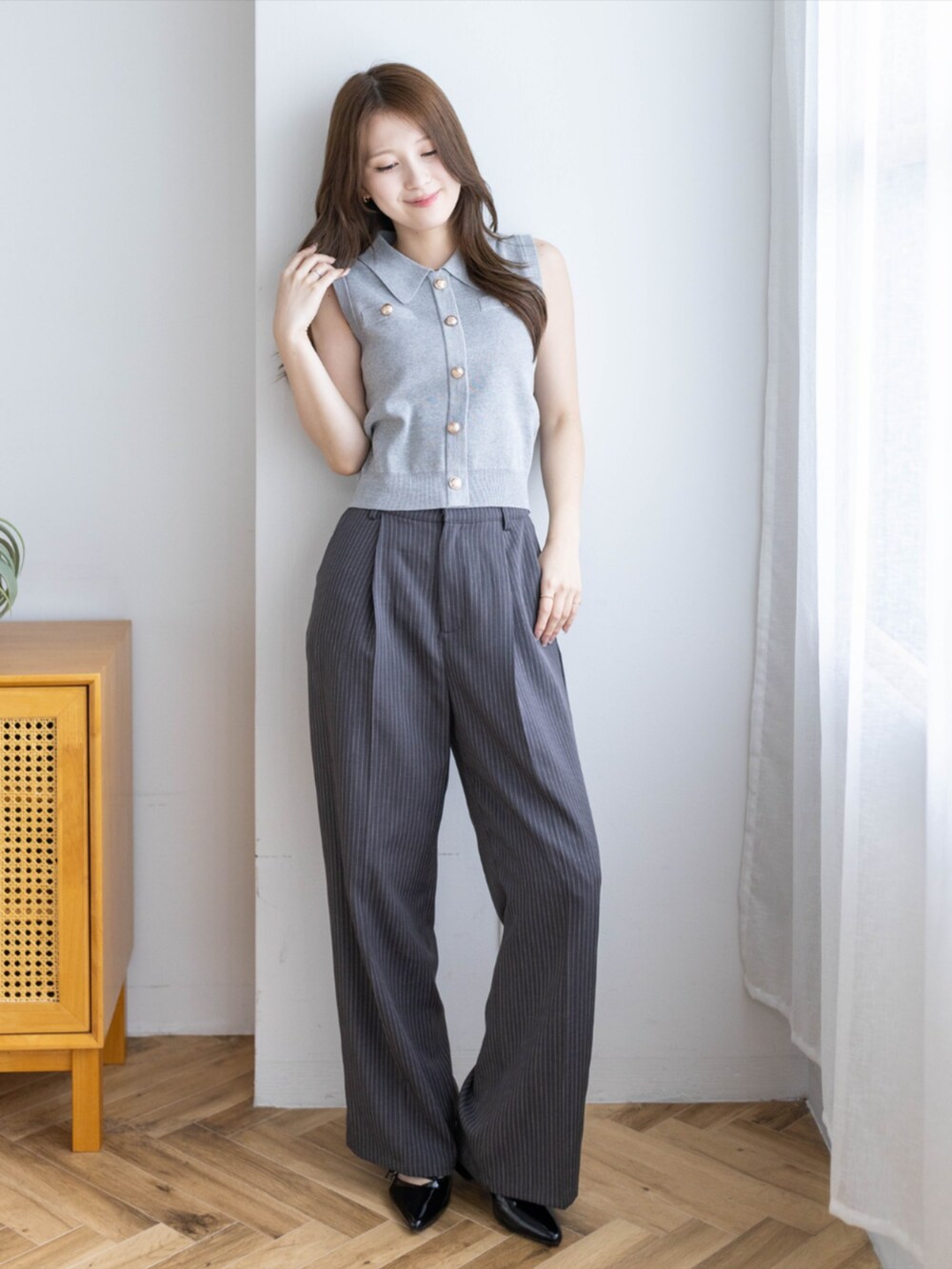 ブラック系のパンプス、グレー系のスラックス、グレー系のニット/セーターを着用したレディースの夏コーディネートの3枚目の写真