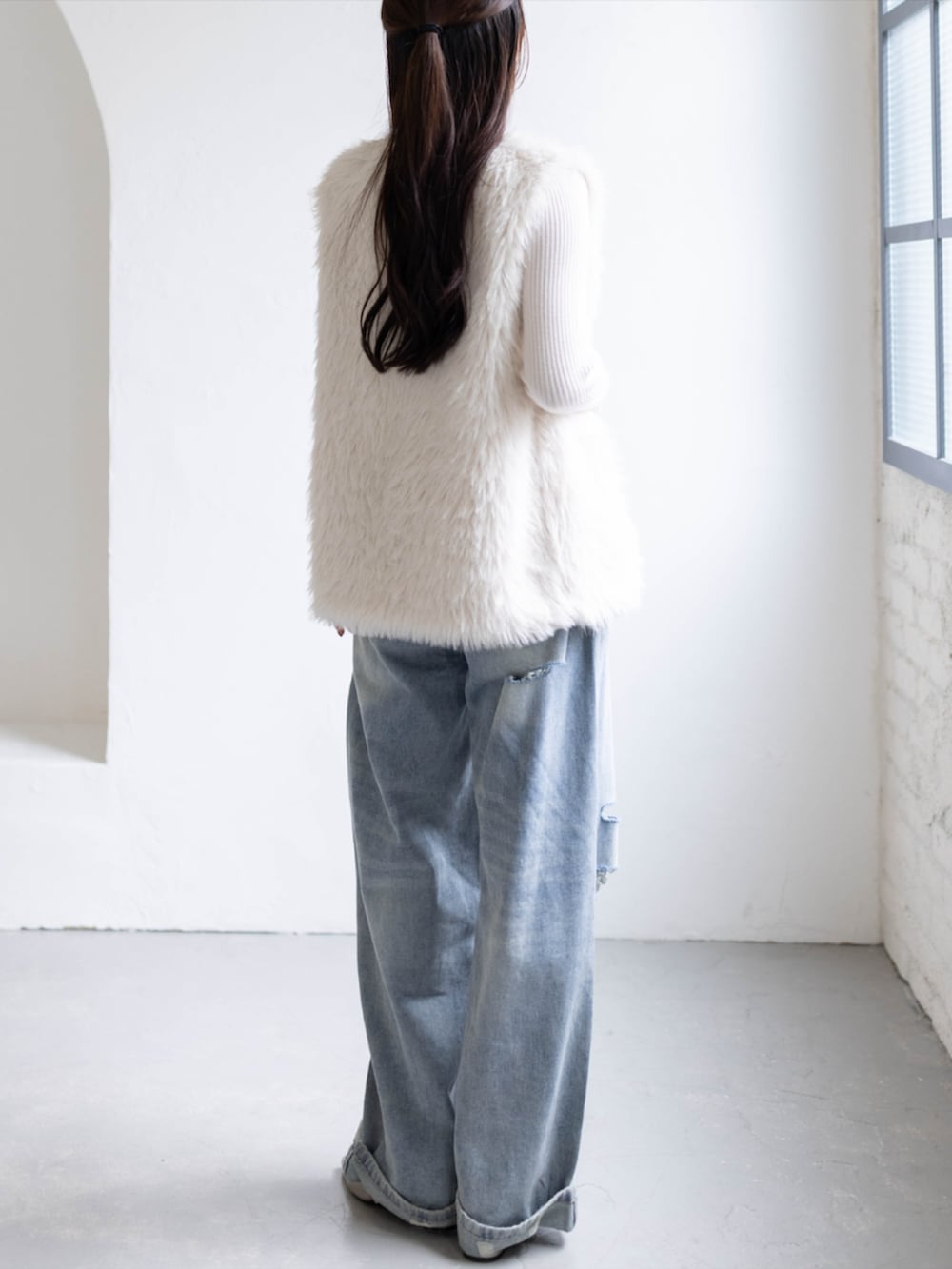 ホワイト系のニット/セーター、ブルー系のデニムパンツ、ホワイト系のその他アウターを着用したレディースの秋コーディネートの4枚目の写真