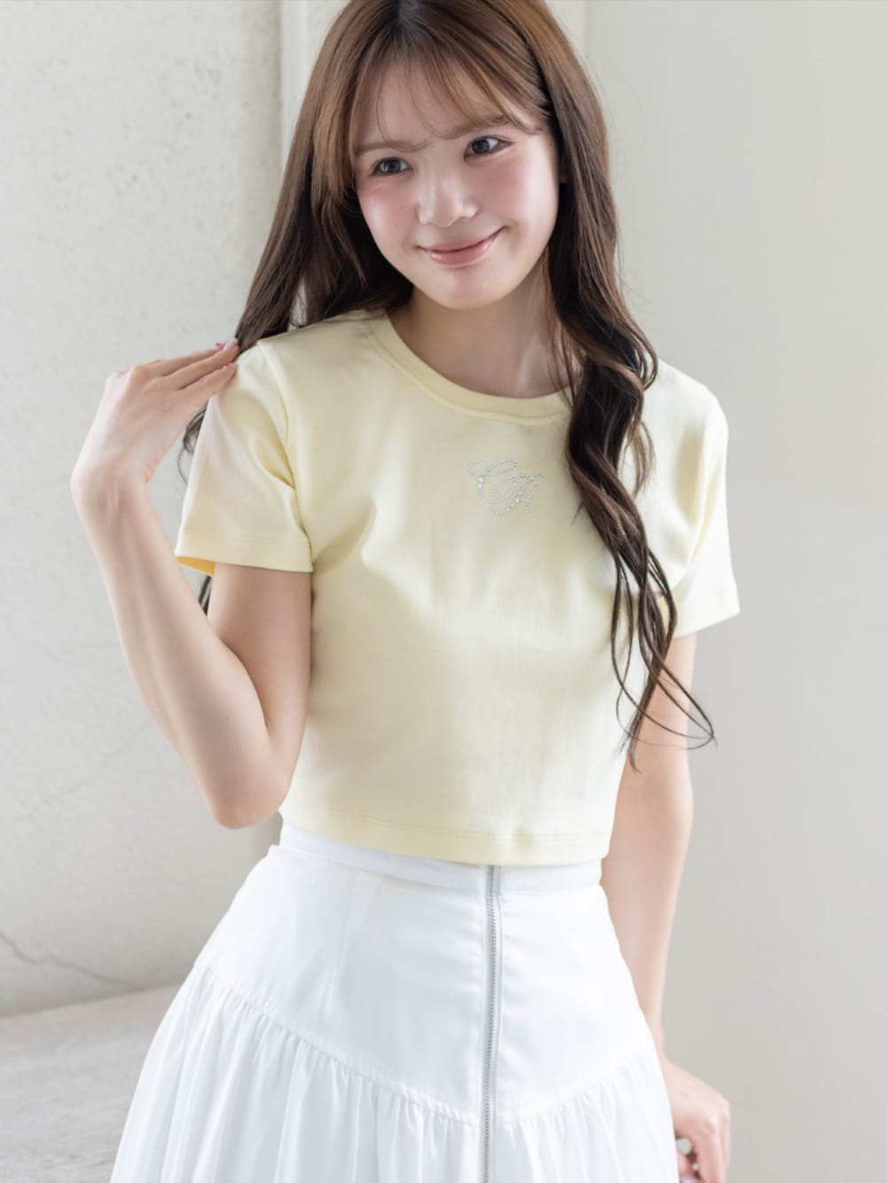 ホワイト系のスカート、ホワイト系のパンプス、イエロー系のTシャツ/カットソーを着用したレディースの夏コーディネートの4枚目の写真