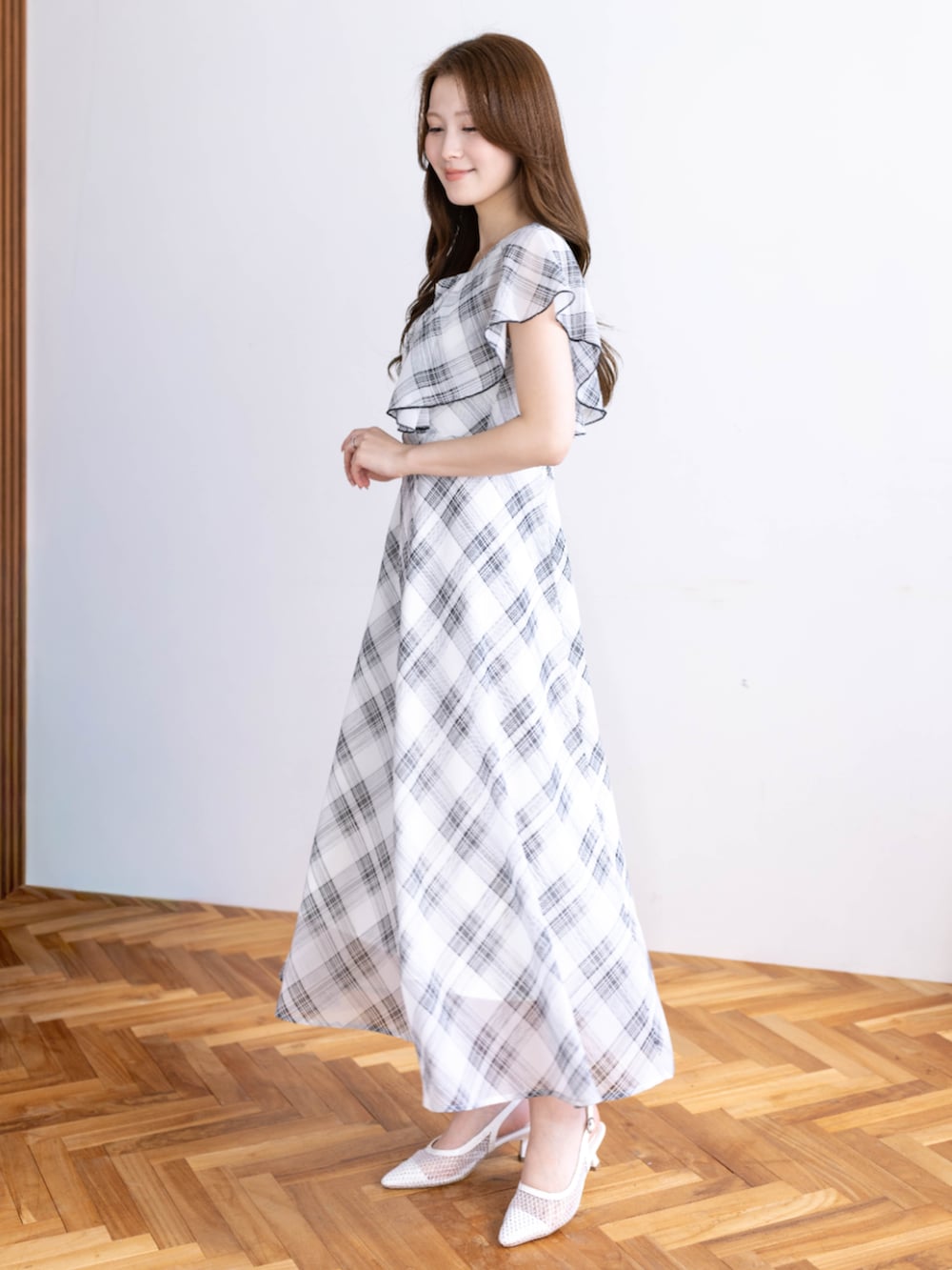 ホワイト系のパンプス、ホワイト系のワンピースを着用したレディースの春コーディネートの2枚目の写真