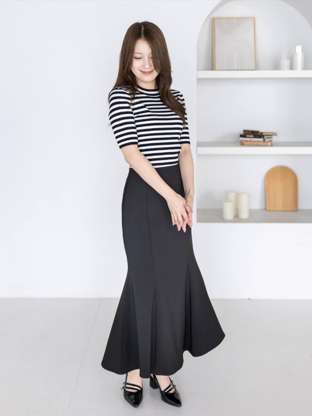 ブラック系のニット/セーター、ブラック系のパンプス、ブラック系のスカートを着用したレディースの夏コーディネートの3枚目の写真